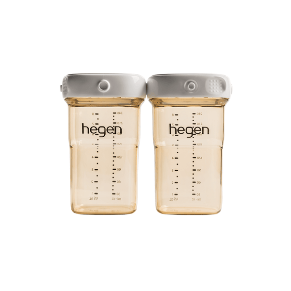 Two transparent Hegen breast milk storage containers with measurement markings and white lids.