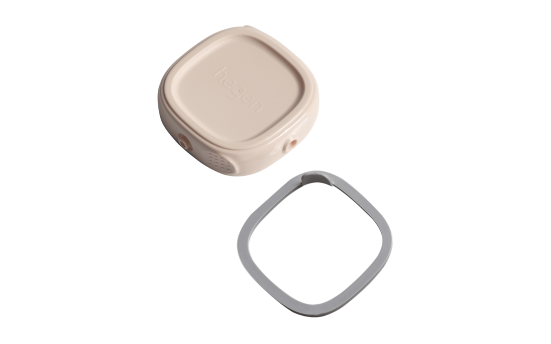 A pink Hegen breast milk storage lid with a snap-on interconnecting button, and a grey lid for storage, stacked on top of each other.